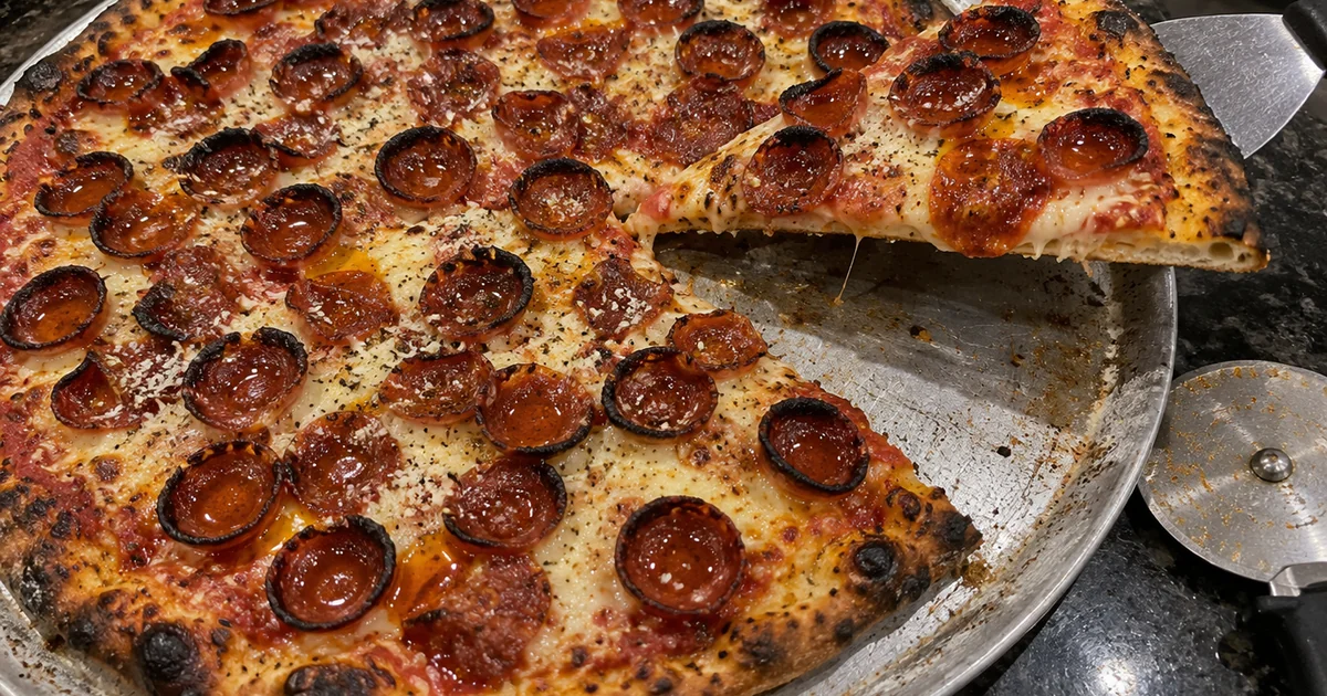 Pepperoni pizza with dozens of small cup-and-char pepperoni curled into crisp cups over browned mozzarella on a New York-style crust